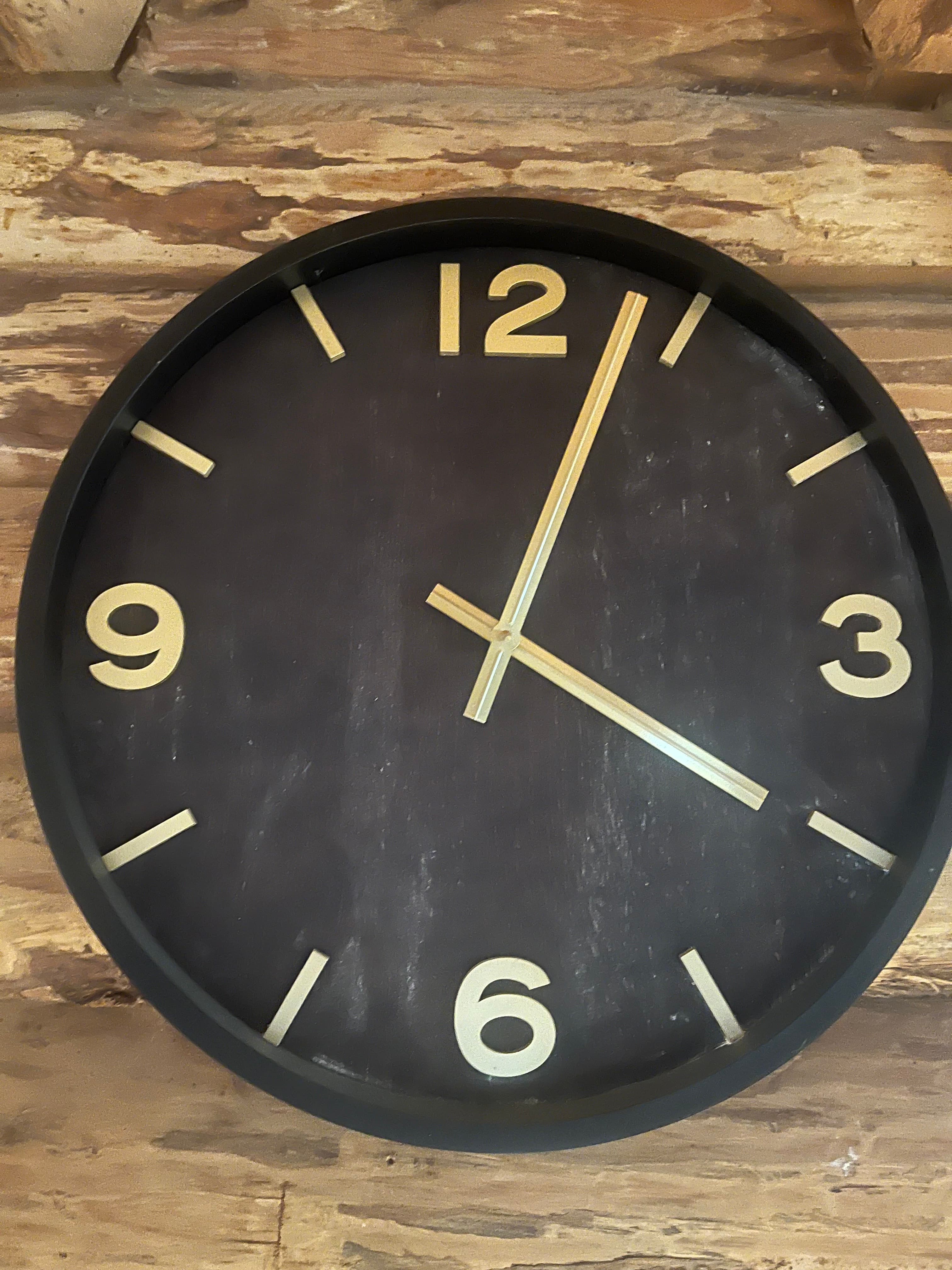 Black and gold clock on log wall