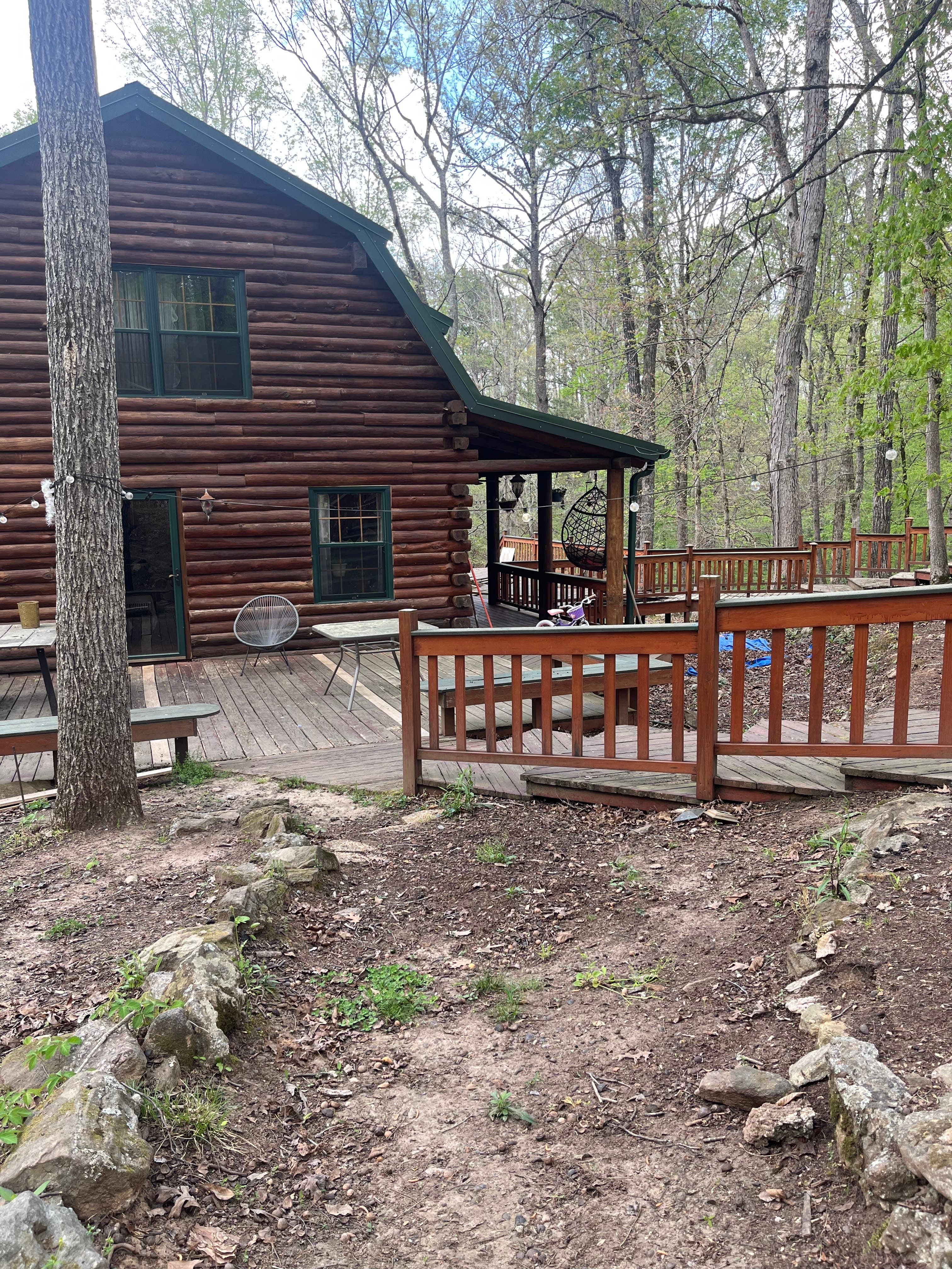 Log cabin with wraparound deck in the woods