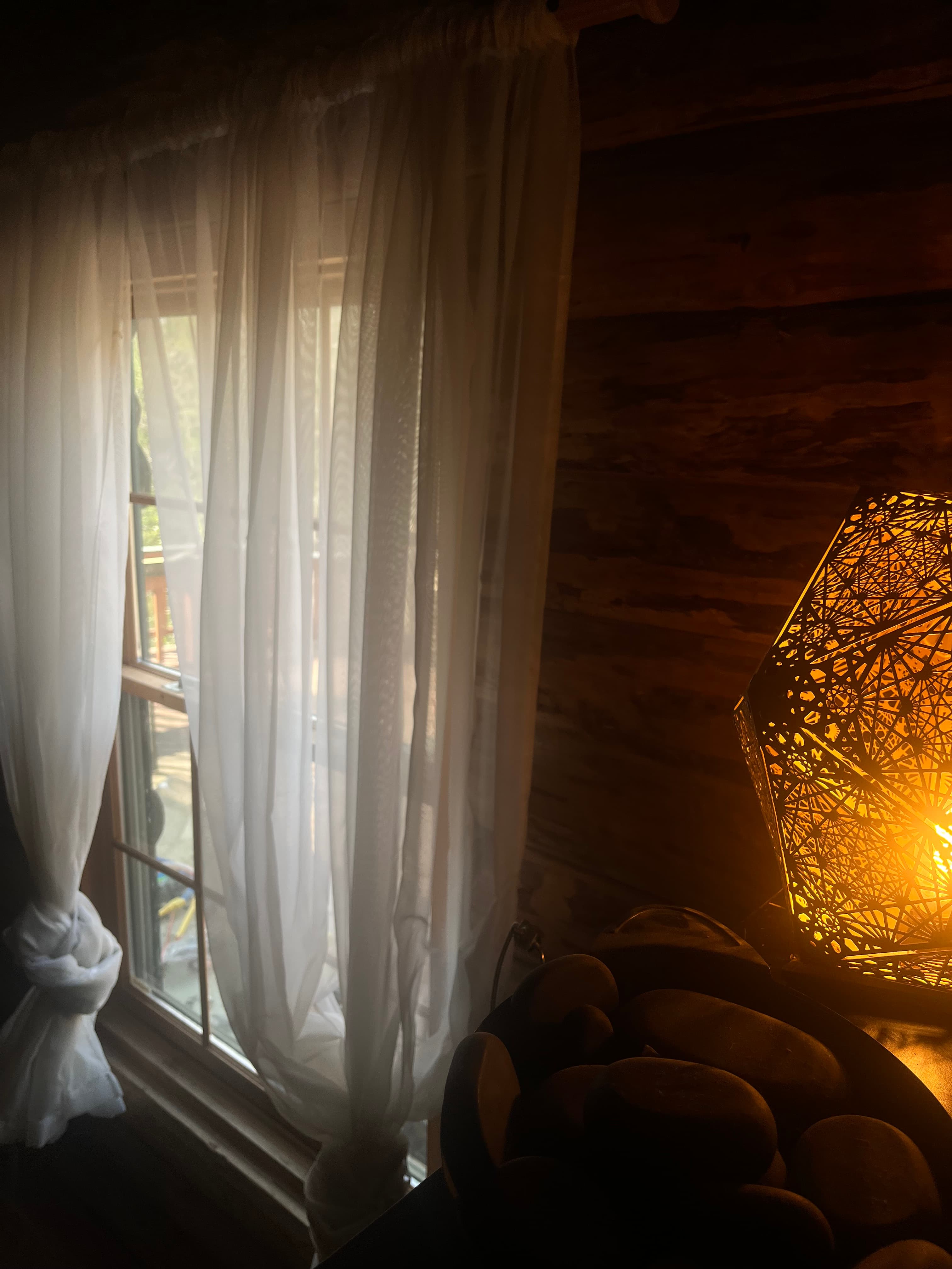 Bedroom with warm pendant light and log walls